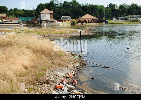 The lake and the shore are littered with the garbage Stock Photo