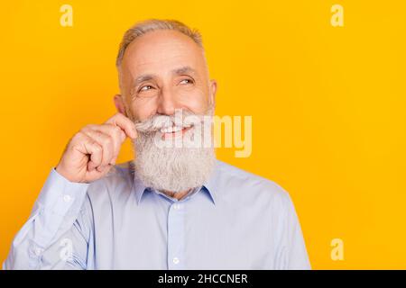 Close-up portrait of attractive cheerful middle-aged man touching beard thinking copy space isolated over gray pastel color background Stock Photo