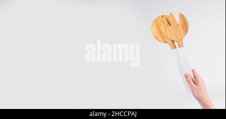 Kitchen utensil in hand on white banner with copy space. Stock Photo