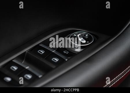 Side mirrors control panel on side door. Car driver adjust side mirror controller. Side mirror control button for adjusting the side mirrors. Stock Photo