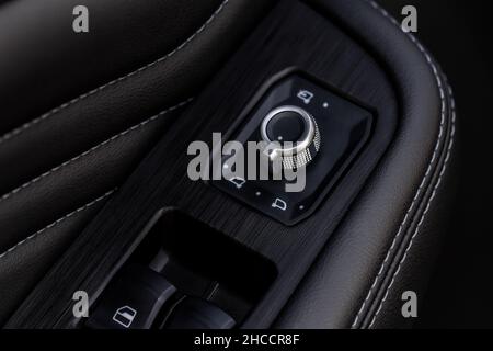 Side mirrors control panel on side door. Car driver adjust side mirror controller. Side mirror control button for adjusting the side mirrors. Stock Photo