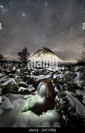 Stob Dearg (the prominent peak on Buachaille Etive More), the River Coupall and the night sky on a wintery day in Glencoe, Scotland, UK. Stock Photo