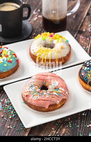 Delicious donuts decorated with different decorations on wooden table Stock Photo