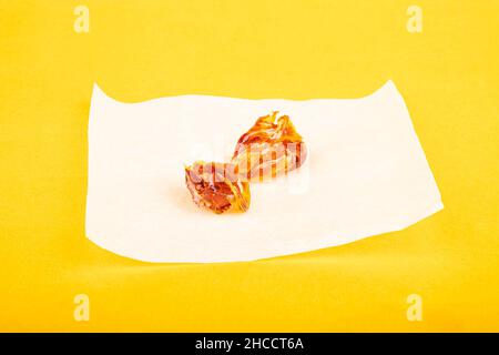 marijuana extract pieces on yellow background cannabis wax on white paper. Stock Photo