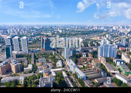 Aerial photography, sunlight illuminates urban residential areas on a summer day against a clouded skyline and blue sky. Stock Photo