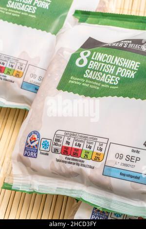 Red Tractor label on packet of ASDA supermarket own-label Lincolnshire sausages. For dietary information labeling, plastic packaging, freezer symbol. Stock Photo