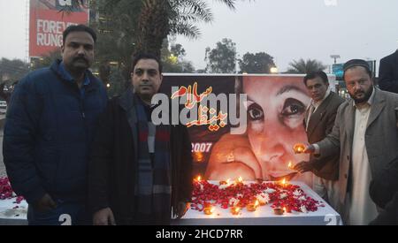 Lahore, Punjab, Pakistan. 27th Dec, 2021. Activists of Pakistani People Party (PPP) enlighten the earth lamp during 14th death anniversary of former prime minister of Pakistan Mohtarma Benazir Bhutto at liberty chowk Lahore (Credit Image: © Rana Sajid Hussain/Pacific Press via ZUMA Press Wire) Credit: ZUMA Press, Inc./Alamy Live News Stock Photo