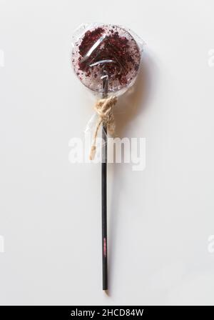 Lollipop on a stick in a transparent wrapper on a white background. Stock Photo