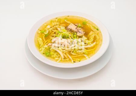 Chicken broth is a soup. It is often served with pieces of meat or with grains of rice or barley, pasta, carrot, yellow potato, celery, white onion, e Stock Photo