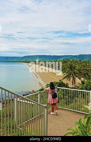 Thai traveller taking in Flagstaff Hill walkway view over 4 Mile Beach in tropical Port Douglas in far north Queensland Australia Stock Photo