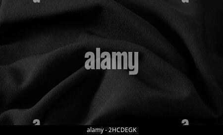 elegant black fabric texture, wrinkled fabric as a background. Stock Photo