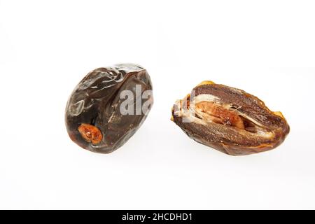 Fresh whole and half dates isolated on white background. Stock Photo