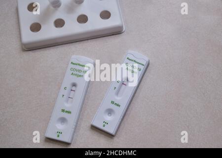 Ottawa, Ontario, Canada - December 25, 2021: Two completed Rapid Response at-home COVID-19 antigen tests show results: positive and negative. Stock Photo