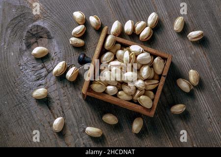 pistachios in a wooden drawer on a rustic wooden background Stock Photo