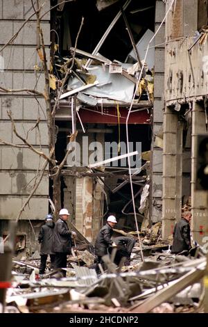 File photo dated 25/04/93 of the clear up of glass and rubble and dangerous structures in Bishopsgate in the City of London following a massive bomb blast showing the seat of the explosion in a crater (left). Issue date: Tuesday December 28, 2021. Stock Photo
