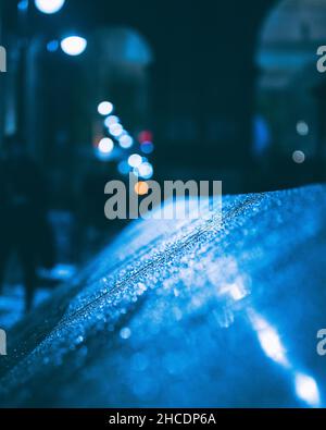 Wet railing at night during the rain with blurred background Stock Photo