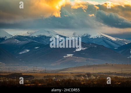 Colorful and stunning sunset sky over the Retezat Massif. Photo taken on 30th of January 2021 in Retezat massif part of the Romanian Carpathian Mounta Stock Photo