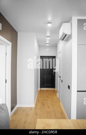 Corridor in the apartment. Wooden floor heating. Air conditioner. Stock Photo