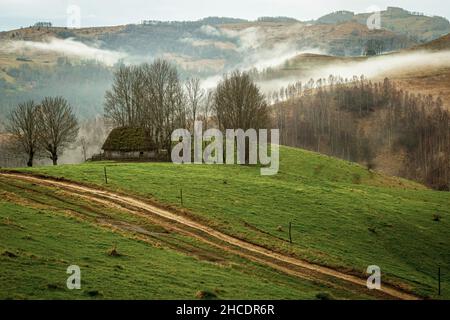 Traditional thatched hut against a picturesque and foggy background. Photo taken on 30th of April 2021 in the old village of Dumesti, Alba county, Rom Stock Photo