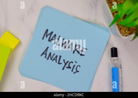 Malware Analysis write on sticky notes isolated on Wooden Table. Stock Photo