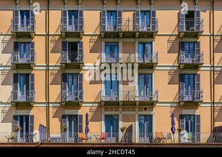 Colorful pattern of windows on an old building façade in Bellagio. Photo taken on 21st of August 2021 in Bellagio, province of Como, Lombardy, Italy. Stock Photo