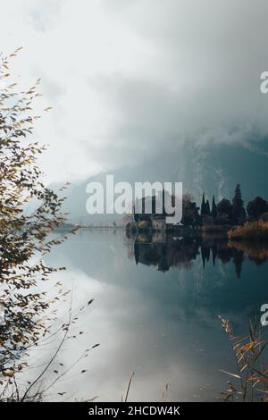 A vertical shot of Lago di Toblino in autumn. Lake in Trentino, Italy. Stock Photo