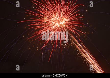 Closeup of red fireworks exploding in the dark sky Stock Photo