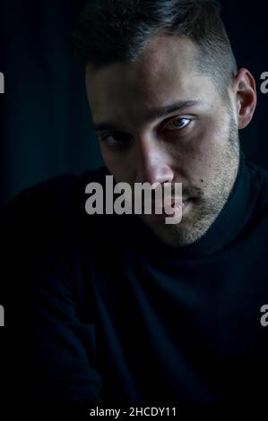 portrait of a young man in a black turtleneck with an intense and captivating look Stock Photo