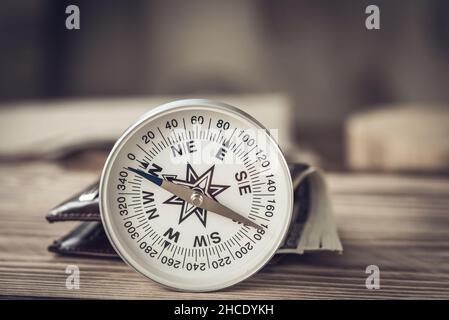 Compass and wallet with american dollars on wooden background as business concept Stock Photo