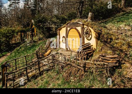 Hobbit house in Czech Hobbiton with three Hobbit holes and cute yellow doors.Fairy tale home in garden.Magic small village from fantasy movie