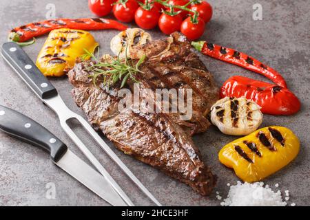 Grilled T-bone beef steak seasoned with rosemary fresh of the summer BBQ Vegetables on grey background close up. Horizontal Stock Photo