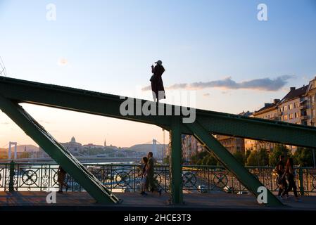 Young woman taking picture standing on the bridge beam Stock Photo