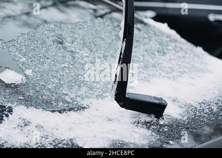 Windshield wiper raised up and icy car windshield. Leave Windshield Wipers Up in the Ice and Snow. Stock Photo