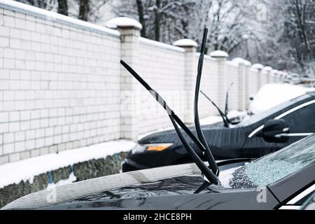Windshield wiper raised up and icy car windshield. Leave Windshield Wipers Up in the Ice and Snow. Stock Photo