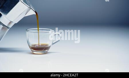 espresso pouring from coffee maker into cup on white and grey,stock image Stock Photo