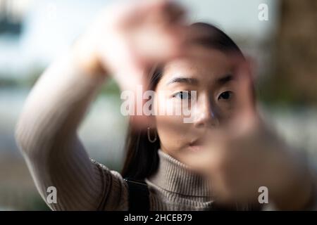 Close up of a young Asian teenage girl framing with her hands Stock Photo