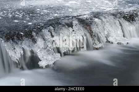 Frozen river cascade with icicles, long exposure photo Stock Photo