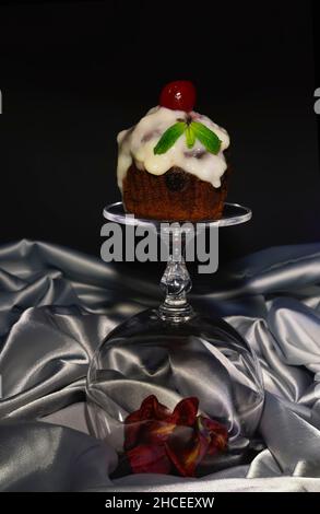 Festive (birthday, valentines day) cupcake decorated with whipped cream,cherries end mint Stock Photo