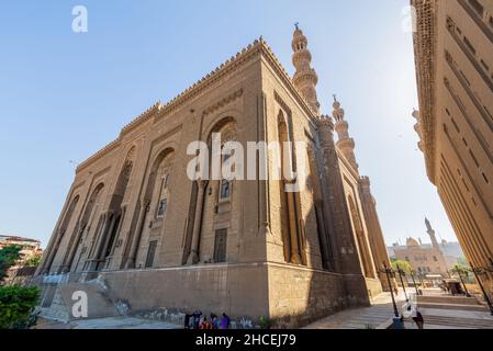Cairo, Egypt - November 27 2021: Facade of Islamic Royal era Mosque of Al Rifai, with side view of Mamluk era Mosque and Madrassa of Sultan Hassan, with few visitors, Old Cairo Stock Photo