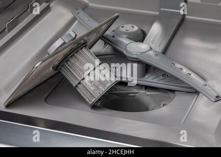 Dishwasher filter screen in bottom of dishwasher. Home appliance repair, maintenance and service concept. Stock Photo