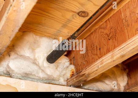Water pipe with insulation in house crawlspace. Plumbing freezing protection, energy savings and home repair Stock Photo