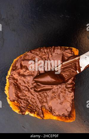 Spreading chocolate cream on toasted bread Stock Photo