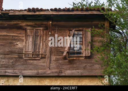 An Old House in Disrepair. Old ruined house in a small village in distant rural area. Broken windows and door. Stock Photo