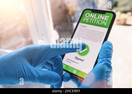 Online Petition on a mobile phone. Close up of caregiver signed Online Petition in a smartphone screen application. Hand holding smart device. Mockup Stock Photo