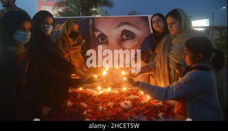 Lahore, Pakistan. 27th Dec, 2021. Activists of Pakistani People Party (PPP) light the earth lamp during 14th death anniversary of former prime minister of Pakistan Mohtarma Benazir Bhutto at liberty chowk Lahore (Photo by Rana Sajid Hussain/Pacific Press/Sipa USA) Credit: Sipa USA/Alamy Live News Stock Photo