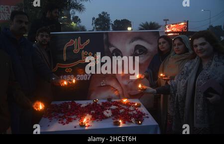 Lahore, Pakistan. 27th Dec, 2021. Activists of Pakistani People Party (PPP) light the earth lamp during 14th death anniversary of former prime minister of Pakistan Mohtarma Benazir Bhutto at liberty chowk Lahore (Photo by Rana Sajid Hussain/Pacific Press/Sipa USA) Credit: Sipa USA/Alamy Live News Stock Photo