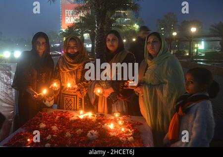 Lahore, Pakistan. 27th Dec, 2021. Activists of Pakistani People Party (PPP) light the earth lamp during 14th death anniversary of former prime minister of Pakistan Mohtarma Benazir Bhutto at liberty chowk Lahore (Photo by Rana Sajid Hussain/Pacific Press/Sipa USA) Credit: Sipa USA/Alamy Live News Stock Photo