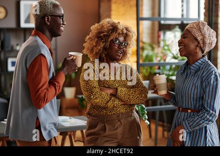 African business people talking to each other and drinking coffee during coffee break at office Stock Photo