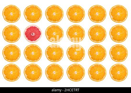 Rows of orange slices and only one grapefruit slice isolated on a white background Stock Photo