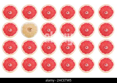 Rows of grapefruit slices and only one pomelo slice isolated on a white background Stock Photo